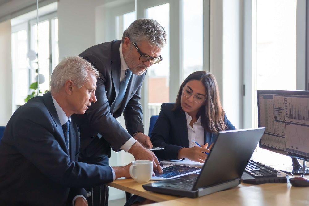 Advisers reviewing a plan together at a desk with a laptop